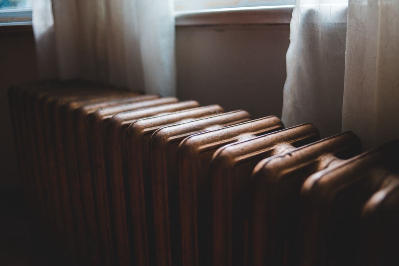 Radiateur en fonte aux reflets cuivrés dans une maison ancienne